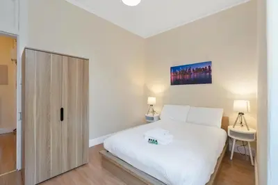 a bedroom with a white bed and a wooden door at Great location Edinburgh city centre in Edinburgh