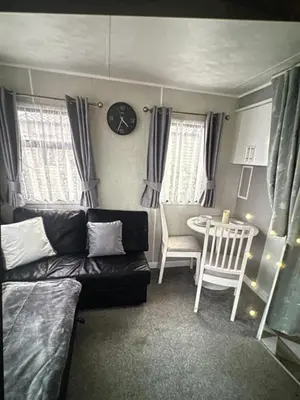 a living room with a couch and a table at Sandylands caravan park in Stevenston