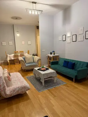 a living room with a green couch and a table at Flat in the heart of Liverpool city centre in Moffat