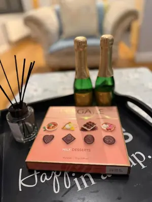 two bottles of wine and a box on a table at Flat in the heart of Liverpool city centre in Moffat