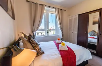 a bedroom with a large bed with a window at Mycosyapartment 47 in Paisley