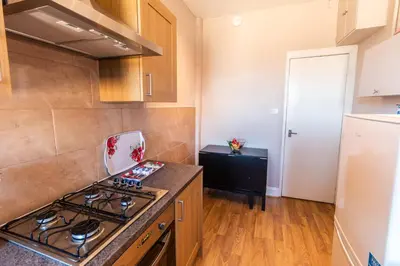 a kitchen with a stove and a refrigerator at Mycosyapartment 47 in Paisley