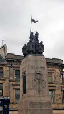 a statue in front of a building with a flag at Mycosyapartment 47 in Paisley