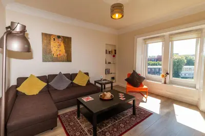 a living room with a couch and a table at Mycosyapartment 47 in Paisley
