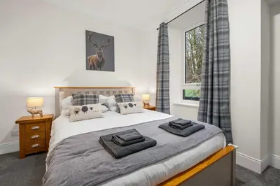 a bedroom with a bed with two towels on it at Stylish 1BR Central Oban Retreat in Oban