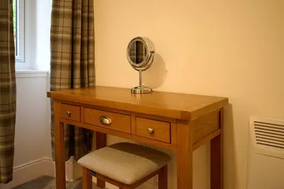 a dressing table with a mirror and a stool at Stylish 1BR Central Oban Retreat in Oban