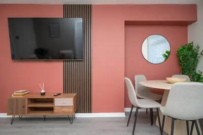 a dining room with a table and a mirror at Vacant Nests Unique 4BR home The Muirhouse in Motherwell