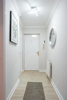 a hallway with a white door and a rug at Burnvale Apartment in Livingston