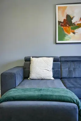 a blue couch with a pillow on top of it at Burnvale Apartment in Livingston