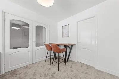 a dining room with a table and two stools at The Brora in High Blantyre