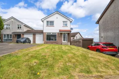a house with a grassy hill in front of it at The Brora in High Blantyre