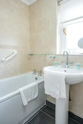 a bathroom with a sink and a bath tub and a sink at Jake's House in Airdrie