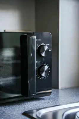 a black microwave oven sitting on a counter at Ochil View House in Falkirk