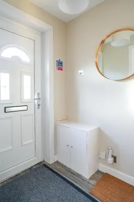 a bathroom with a white door and a mirror at Ochil View House in Falkirk