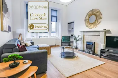 a living room with a blue couch and a fireplace at Cambridge Apartment in Glasgow