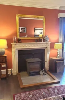 a fireplace with a mirror above it in a living room at 3 Bed House - Mountain Views Bbq Firepit in Dunoon