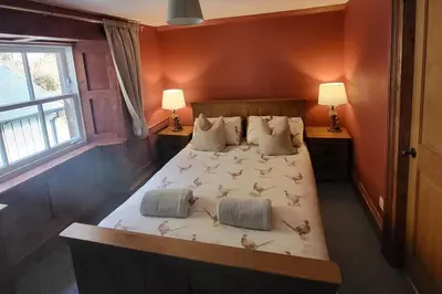 a bedroom with a bed with birds on it at 3 Bed House - Mountain Views Bbq Firepit in Dunoon