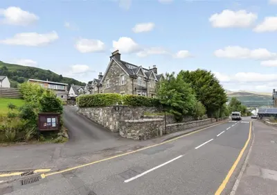 a house on the side of a road at Balmore - 3 Bedroom Townhouse, heart of Killin in Killin