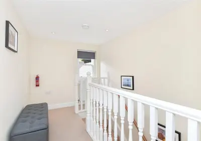 a white staircase with a blue chair in a house at Balmore - 3 Bedroom Townhouse, heart of Killin in Killin