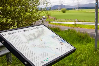 a map sitting on a park bench in the grass at Highland Gateway Glamping in Clackmannan