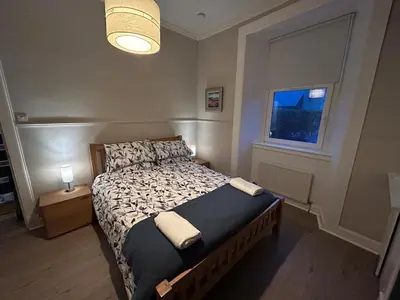 a bedroom with a bed and a window at 77 West Princes St, cosy 1 bed ground floor in Helensburgh