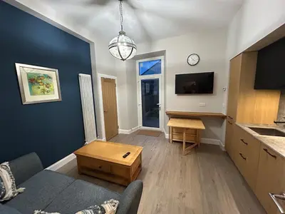 a living room with a couch and a table at 77 West Princes St, cosy 1 bed ground floor in Helensburgh