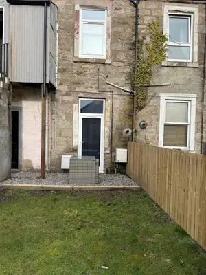 a brick building with a door and a fence at 77 West Princes St, cosy 1 bed ground floor in Helensburgh