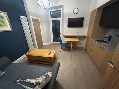 a living room with a couch and a table at 77 West Princes St, cosy 1 bed ground floor in Helensburgh