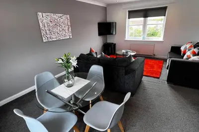 a living room with a couch and a table and chairs at 2 Bed Apartment Sleeps 4 -Near Airport -WiFi & Tv in Renfrew