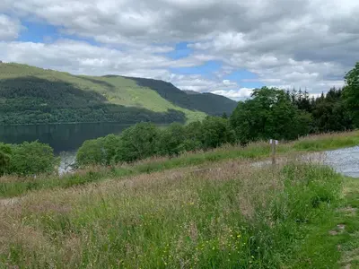 a view of a body of water with mountains in the background at The Tractor Shed- Elevated Hot Tub with Loch Views