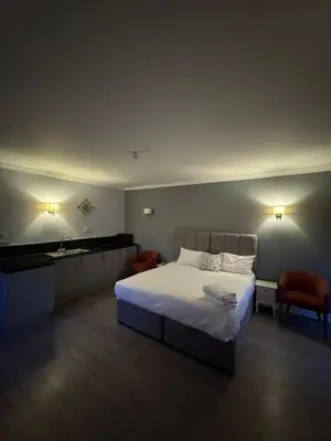a bedroom with a white bed and a sink at Edinburgh West Residence in Edinburgh