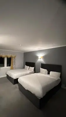 a bedroom with two beds with white sheets at Edinburgh West Residence in Edinburgh