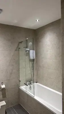 a bathroom with a shower and a bath tub at Edinburgh West Residence in Edinburgh