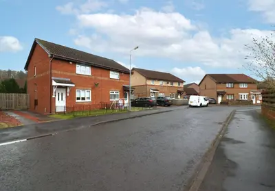 an empty street in a residential neighborhood with houses at Signature Summerhill House in Bearsden