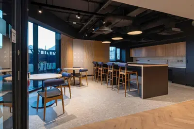 a group of tables and chairs in a room with windows at For Students Only - Haymarket Yard in Edinburgh in Edinburgh