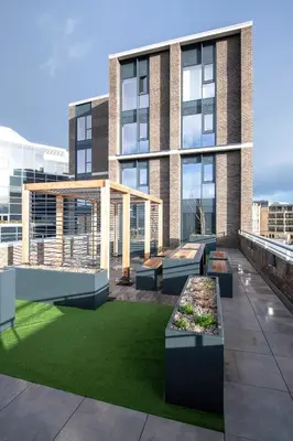 a building with benches and grass in front of it at For Students Only - Haymarket Yard in Edinburgh in Edinburgh