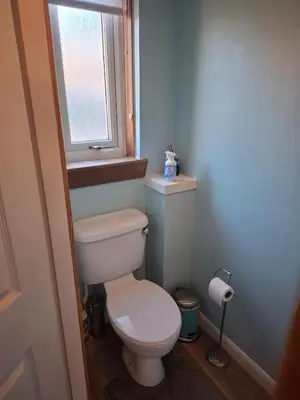 a small bathroom with a toilet and a window at Cheerful 3 bedroom house with free parking in Hurlet