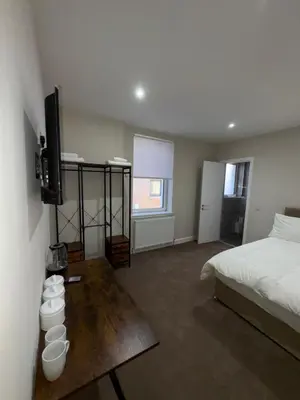 a bedroom with a bed and a table with a television at Skips in Largs