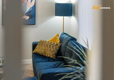 a blue couch in a living room with a lamp at 2 Bed Home in Paisley I Sleeps 4 in Paisley
