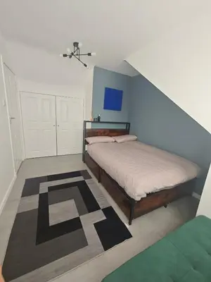 a bedroom with a bed and a blue wall at The Boswall Residence in Edinburgh