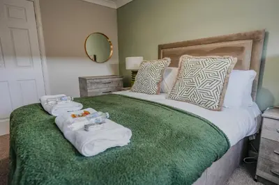 a bedroom with a large bed with towels on it at Dunward House in Livingston