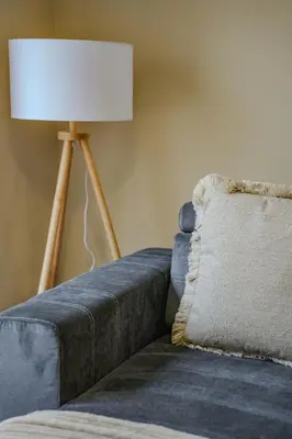 a lamp sitting next to a blue couch with a pillow at Dunward House in Livingston