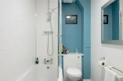a bathroom with a shower with a toilet and a sink at Stylish 2-Bed Flat with Balcony Near Haymarket - Pass the Keys in Edinburgh