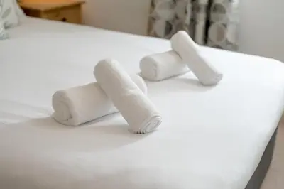three rolls of toilet paper on a bed at Stylish 2-Bed Flat with Balcony Near Haymarket - Pass the Keys in Edinburgh