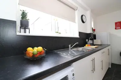 a kitchen with a bowl of fruit on the counter at Signature Greenfield House in Wishaw
