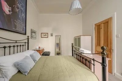 a bedroom with a bed and a refrigerator in it at Quiet 1-Bed Flat by the Meadows in Edinburgh
