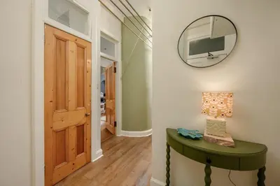 a hallway with a green table and a mirror at Quiet 1-Bed Flat by the Meadows in Edinburgh