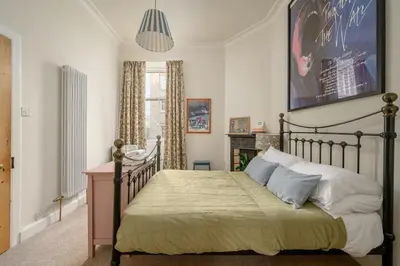 a bedroom with a bed with a poster on the wall at Quiet 1-Bed Flat by the Meadows in Edinburgh