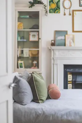 a room with pillows on a bed with a fireplace at Luxury MArylebone Village family home in Moffat