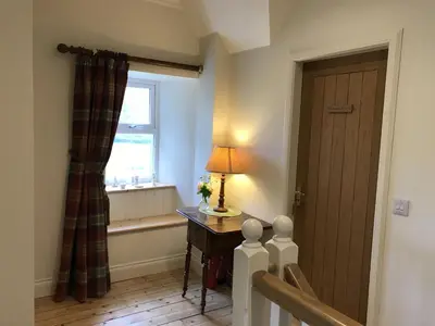 a room with a window and a table with a lamp at Ederline Farm Cottage in Lochgilphead